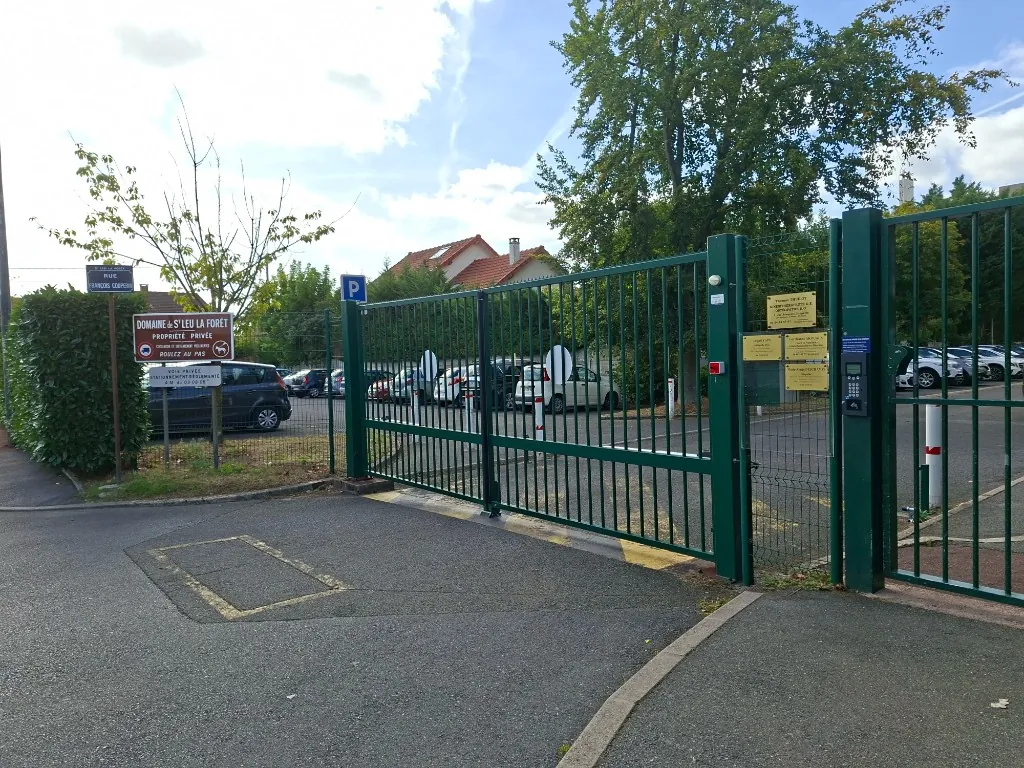 Le portail vert de la résidence, rue François Couperin, avec le parking derrière.